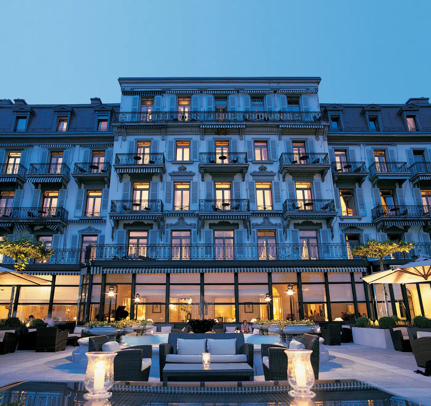 Terrasse d'un grand hôtel suisse illuminée à la tombée du jour