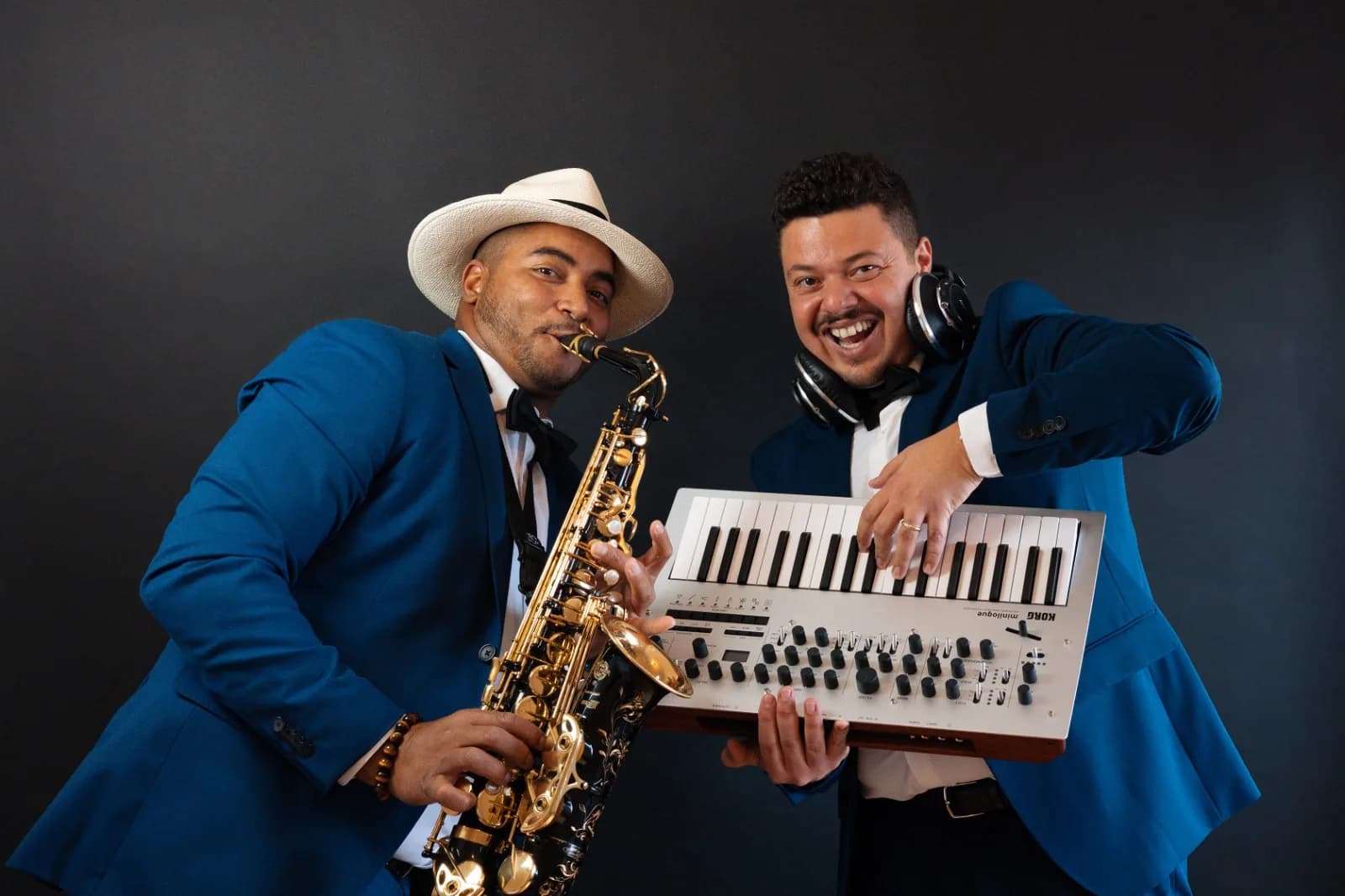 The Jazzy Brothers duo in the studio, saxophone and keyboard, in blue suits
