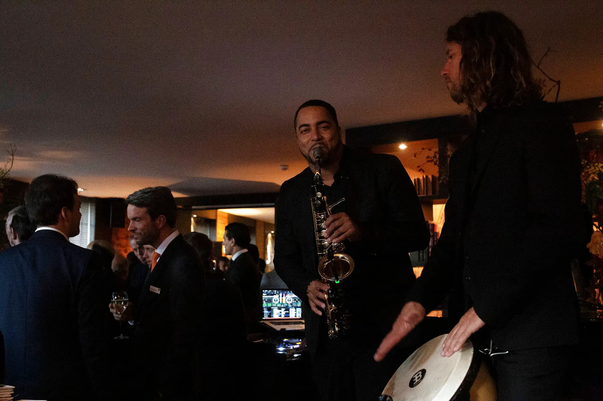 Saxophonist and percussionist playing between the tables during a corporate cocktail