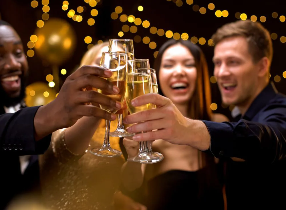 Guests toasting with champagne under the string lights