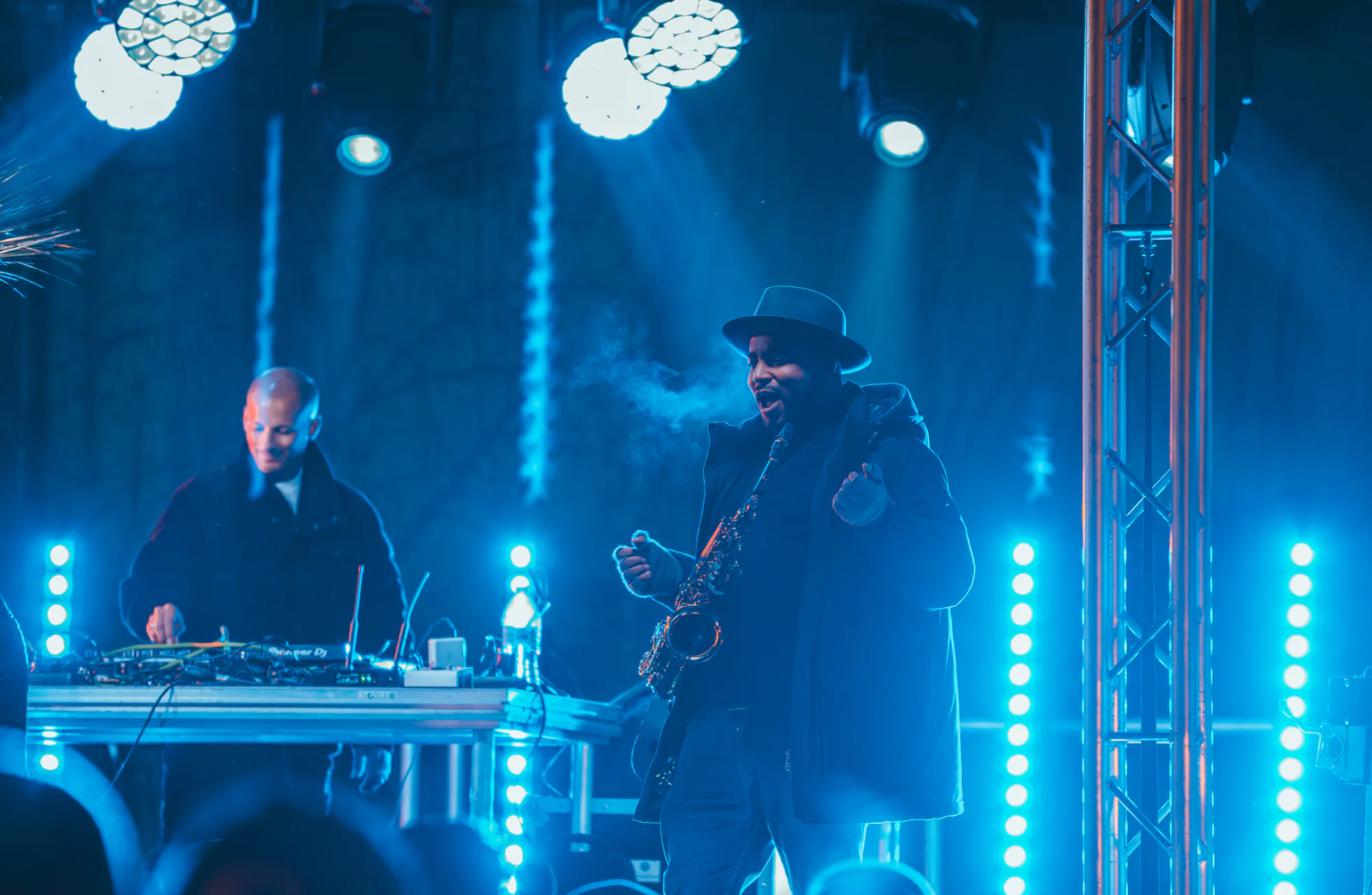 Saxophonist and DJ playing as a duo on the stage of an open-air New Year's Eve party