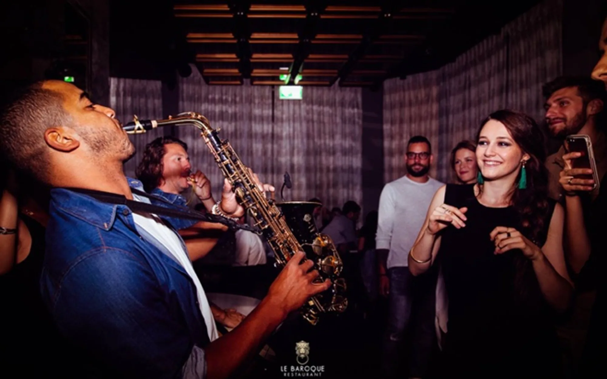 Saxophoniste jouant au milieu des invités pendant une soirée privée