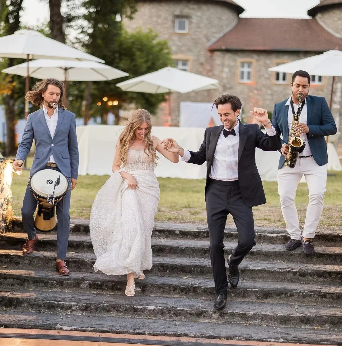 Saxophonist and percussionist accompanying the newlyweds down a château staircase