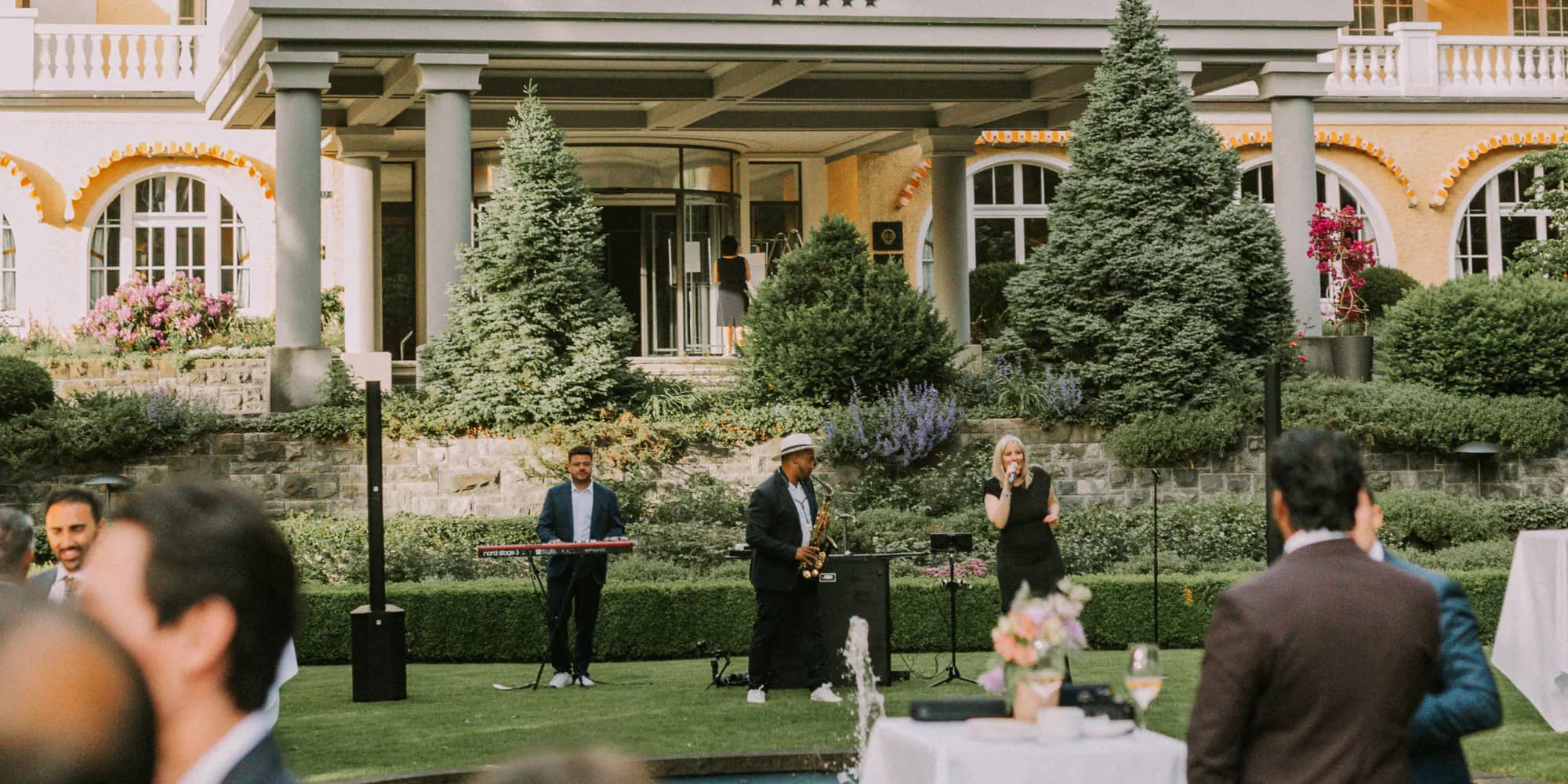 Trio clavier, saxophone et chant jouant devant la façade d'un palace pendant un cocktail de mariage